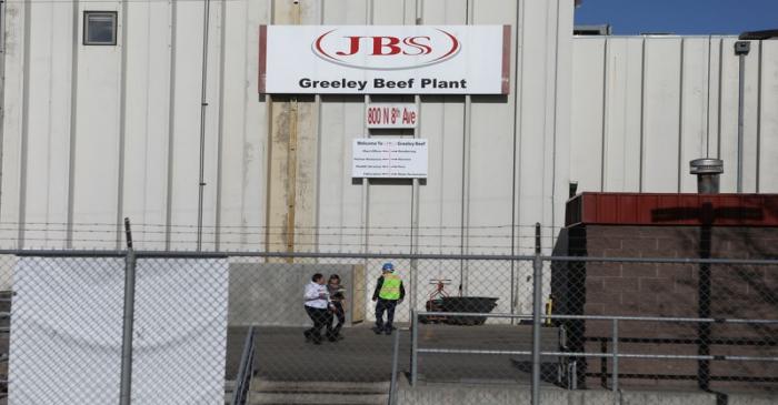 Employees walk around without face mask at the JBS USA meat packing plant in Greeley
