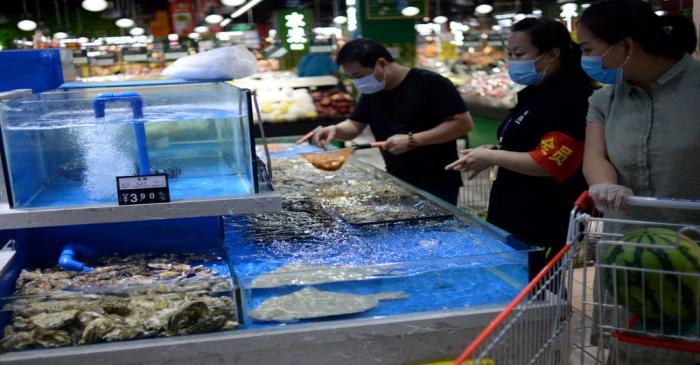 FILE PHOTO: Customers wearing face masks shop for live seafood at a Carrefour supermarket in