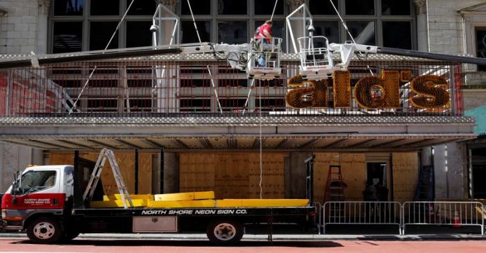 Workers remove a sign from a permanently closed McDonald's restaurant in Times Square in New