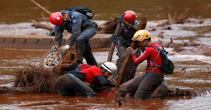 Members of a rescue team search for victims of a collapsed tailings dam owned by Brazilian