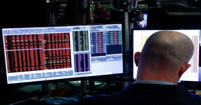 FILE PHOTO: Traders work on the floor of the New York Stock Exchange (NYSE) in New York