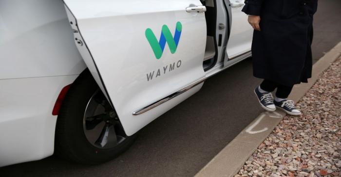 Reuters reporter Alexandria Sage steps out of a Waymo self-driving vehicle during a