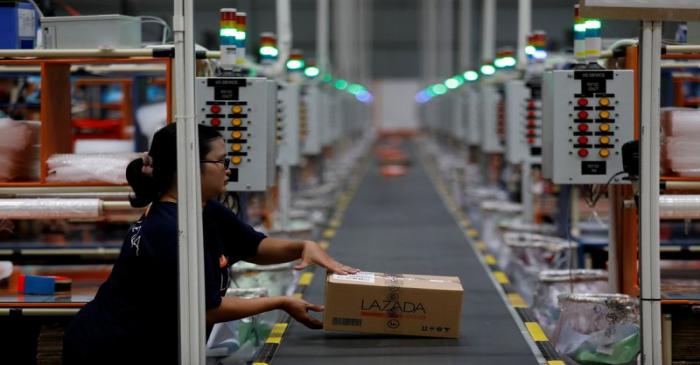 FILE PHOTO: A worker places a package for delivery on a conveyor belt at online retailer
