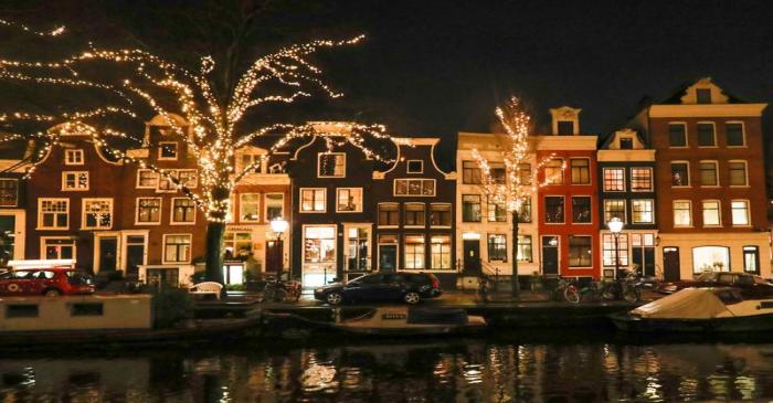 FILE PHOTO: Trees are illuminated near a canal in central Amsterdam