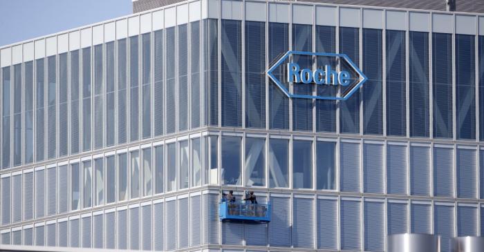 Workers clean windows of a building of Roche in Rotkreuz