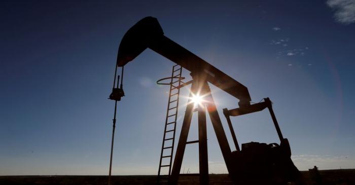 FILE PHOTO: The sun is seen behind a crude oil pump jack in the Permian Basin in Loving County