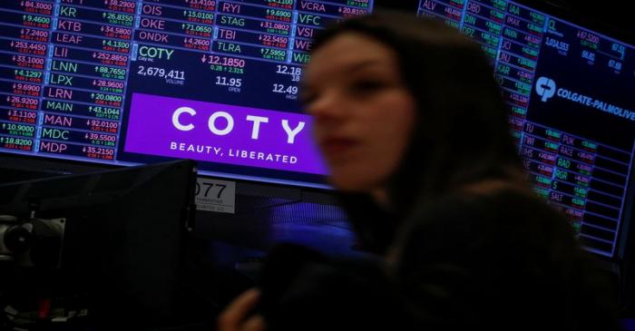 A screen displays the logo and trading information for Coty Inc at the NYSE in New York