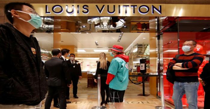 FILE PHOTO: Customers stand in front of a Louis Vuitton shop inside the department store Le