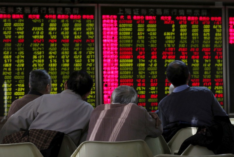 FILE PHOTO: Men look at an electronic board showing stock information at a brokerage house in