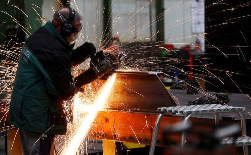FILE PHOTO: A worker grinds metal at the machine-building company Zemmler Siebanlagen in Massen