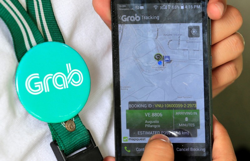 A Grab employee shows the Apps used to book a cab in the metro Manila