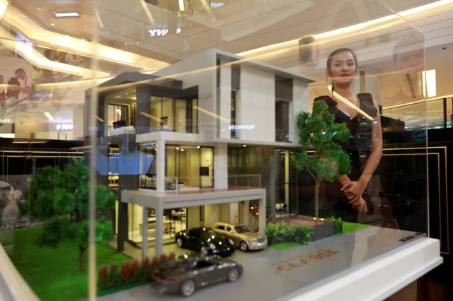 Promotion staff sell their new condo project in a shopping center in Bangkok