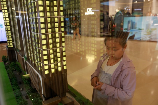 A girl looks at a new condo project model during a promotion show in a shopping center in