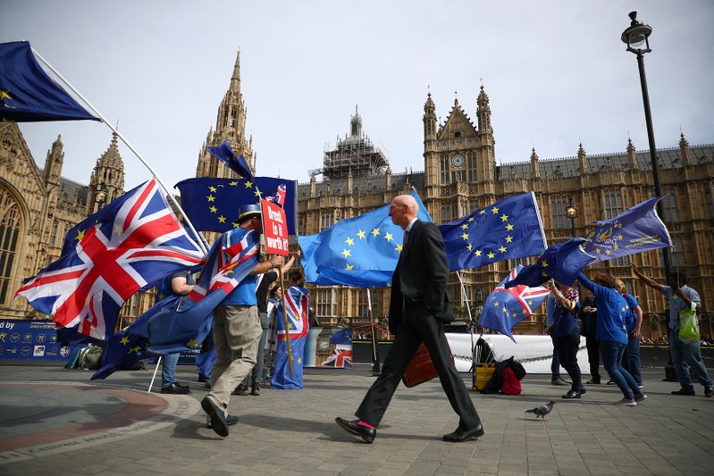 Anti-Brexit demonstrators wave flags outside the Houses of Parliament, in London