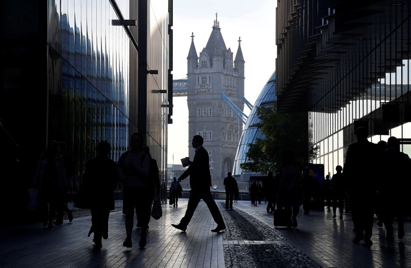 Workers are seen in the More London district, with Tower Bridge behind during the morning rush