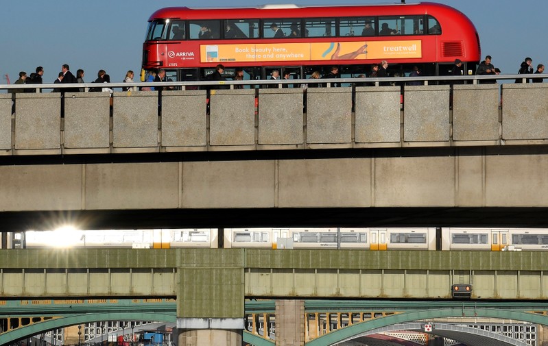 Workers are seen crossing London Bridge during the morning rush hour in London