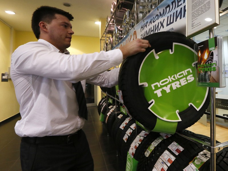 Employee places a Nokian tyre at the 