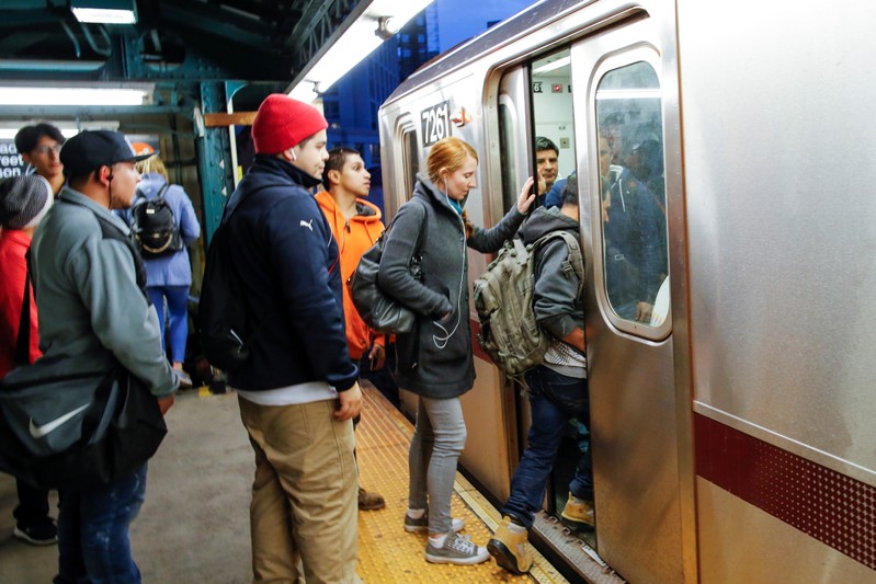 People try to catch the 7 train in Long Island City, where Amazon.com is reportedly considering