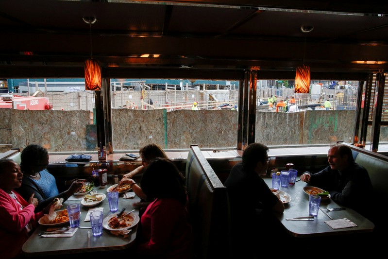 People eat inside Court Square Diner as people work in a building construction in Long Island