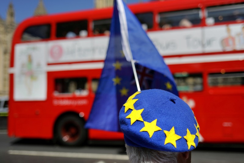 A bus passes as anti-Brexit demonstrators protest opposite the Houses of Parliament