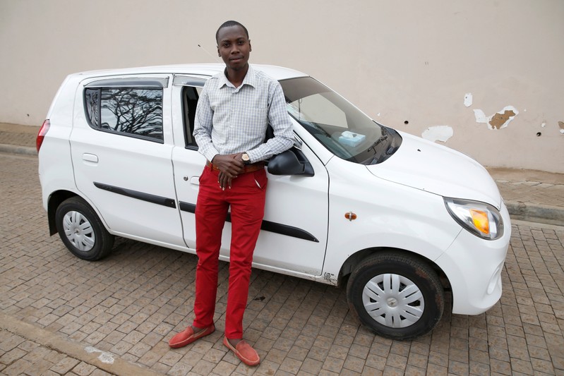Kenyan Uber driver Joe Wanyoike poses next to his car during an interview with Reuters in