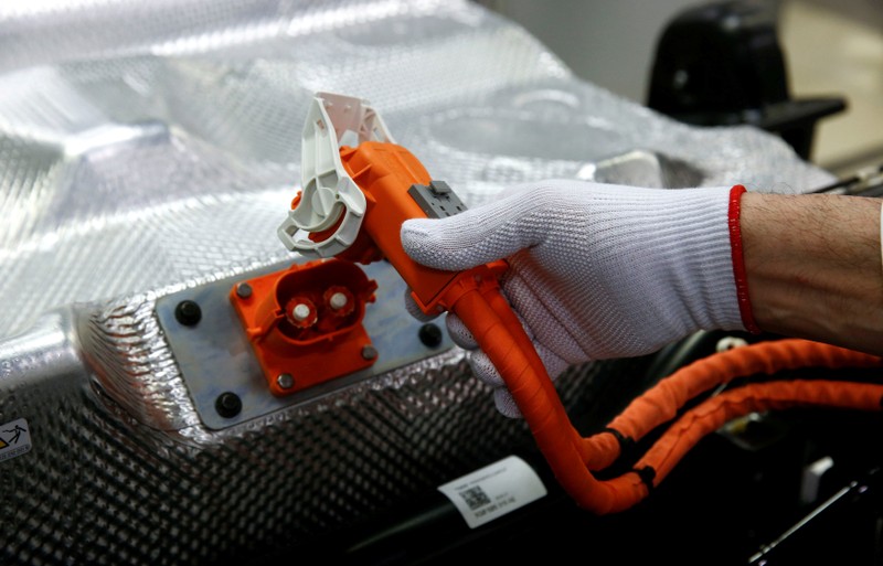 FILE PHOTO: Worker connects the battery during the assembly of a VW e-Golf electric car at the