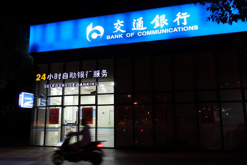 Man rides past a Bank of Communications branch in Shanghai