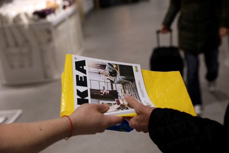 FILE PHOTO: An IKEA worker hands out catalogues at the entrance to an IKEA store in Madrid