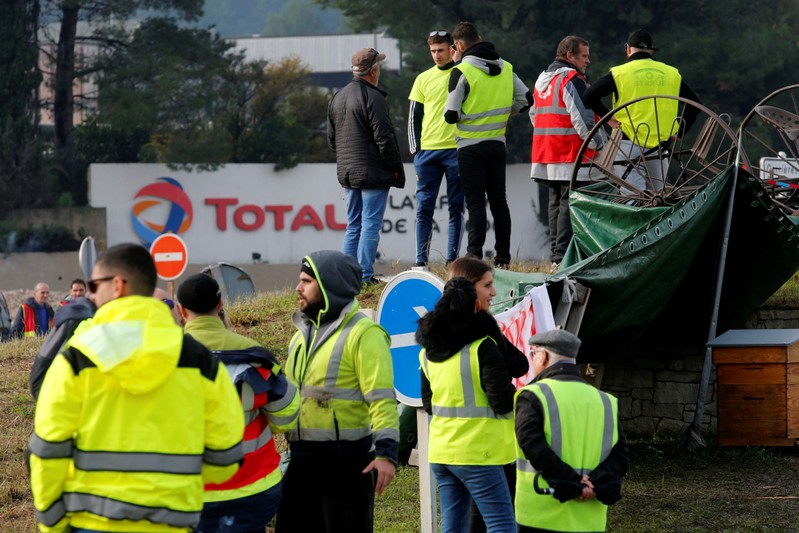Demonstrators wearing yellow vests, a symbol of a French drivers' protest against higher fuel