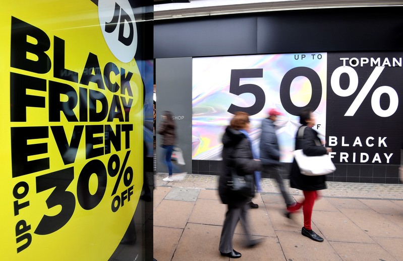 Shoppers walk past Black Friday signage on Oxford Street in London