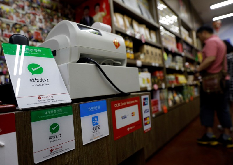Signs accepting WeChat Pay and AliPay are displayed at a shop in Singapore