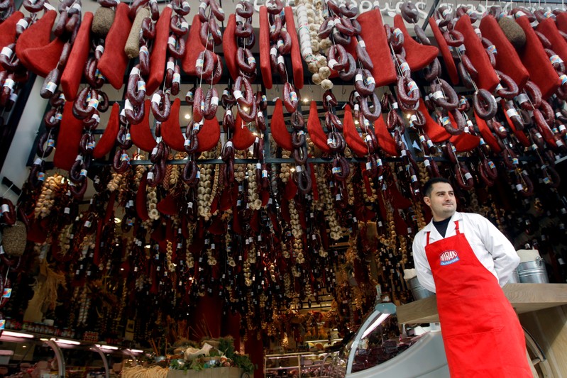FILE PHOTO:  A grocer stands outside his shop in Athens