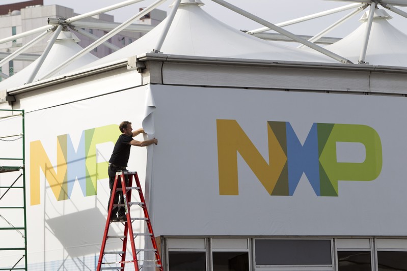 A man works on a tent for NXP Semiconductors in preparation for the 2015 International Consumer