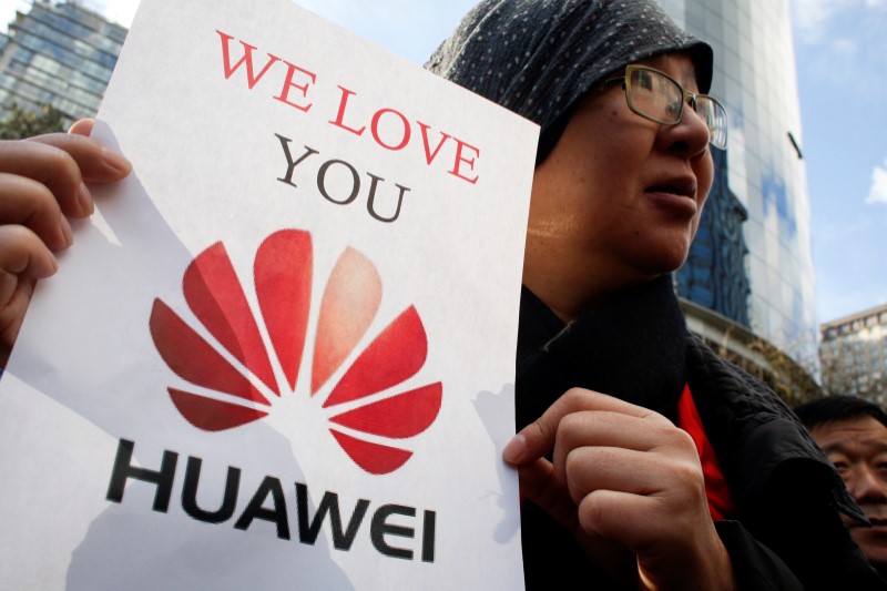 Lisa Duan, a visitor from China, holds a sign in support of Huawei outside of the B.C. Supreme