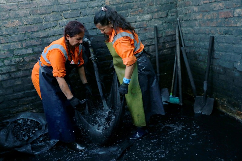 Women wash the waste stone from one of the mines of the company Fura in Coscuez