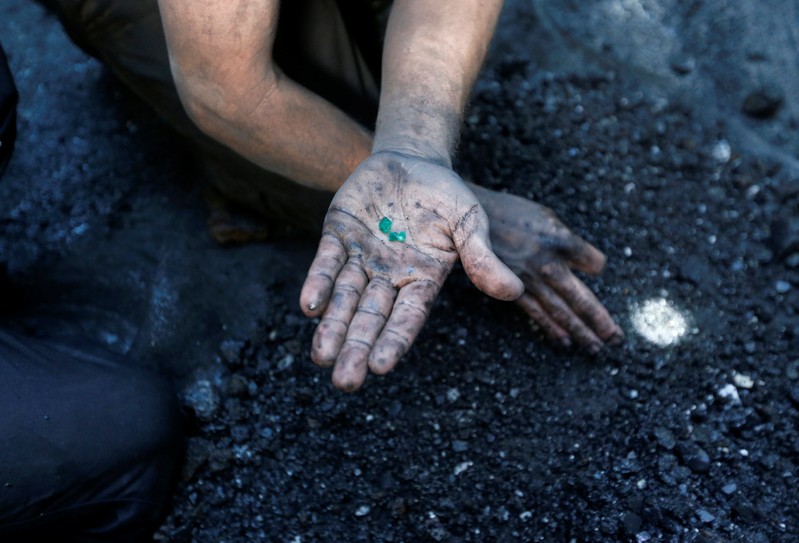 An informal miner shows few emeralds on the outskirts of a mine in the company Fura in Coscuez