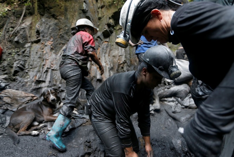 Informal miners wash stone waste in search of emeralds on the outskirts of a mine in the