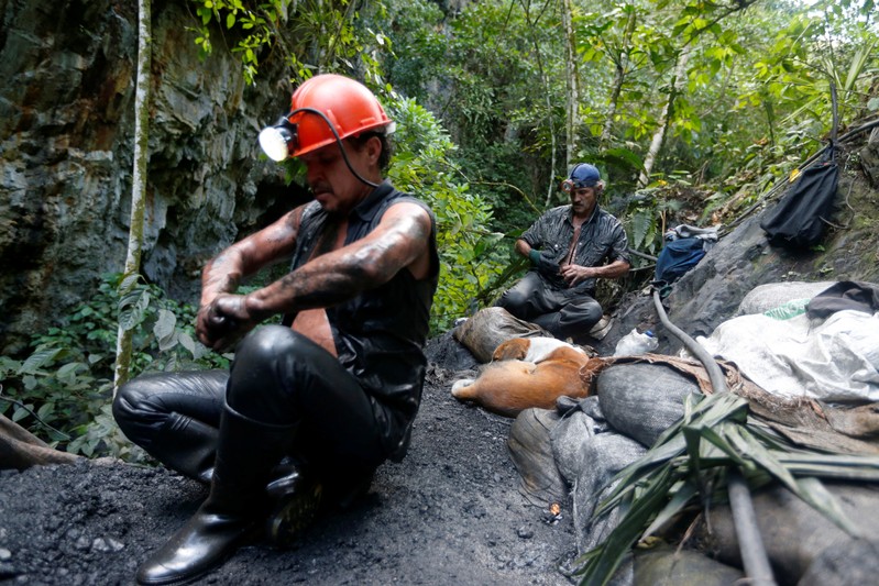 Informal miners rest after digging inside a mine of the company Fura in Coscuez