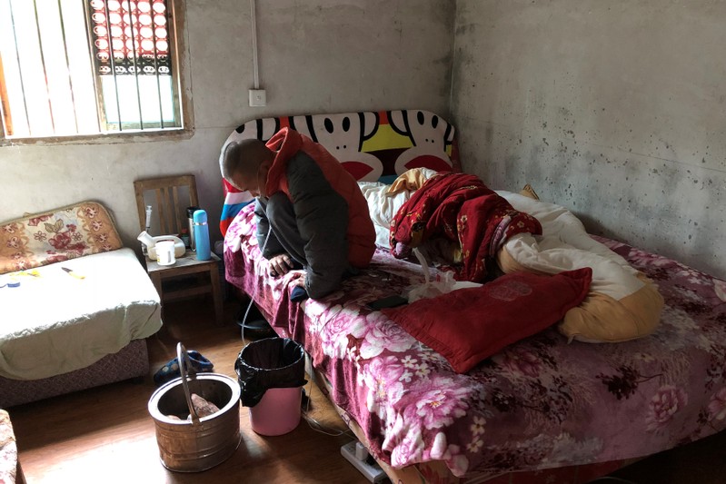 Wang Zhaohong, who suffers from silicosis, is seen on his bed in Sangzhi