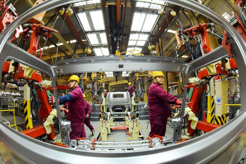 Employees work on a production line manufacturing light trucks at a JAC Motors plant in Weifang