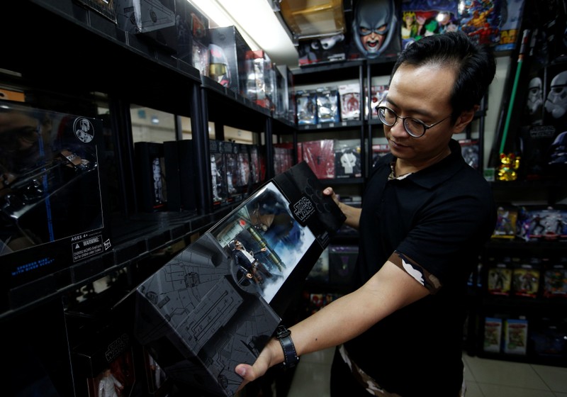 Andy Kurniawan, who is the owner of an action figure store, shows a Star Wars action figure at