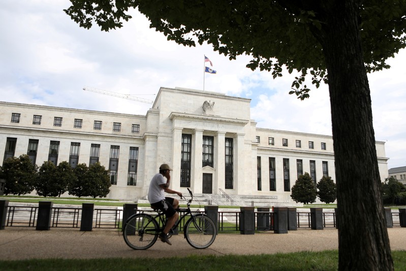 FILE PHOTO: A cyclist passes the Federal Reserve building in Washington