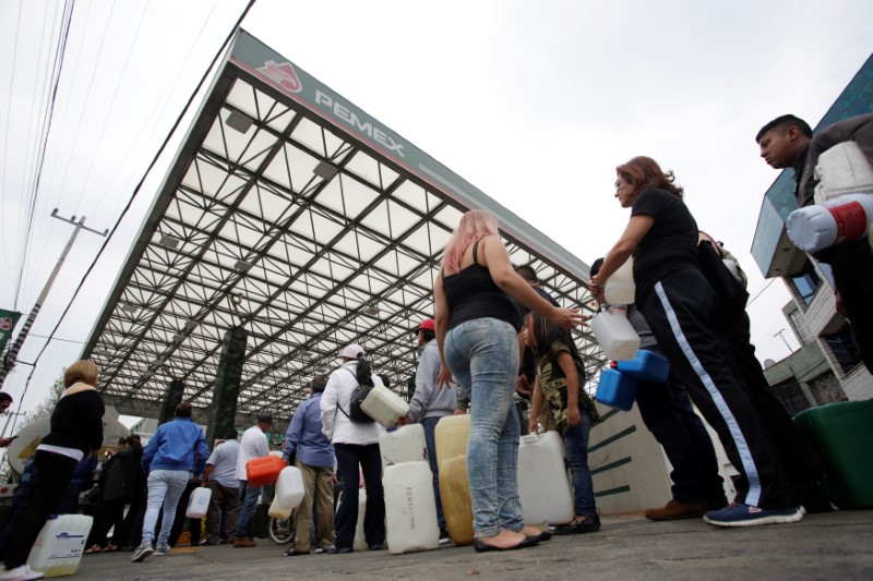 People queue to buy gasoline at a gas station in Mexico City