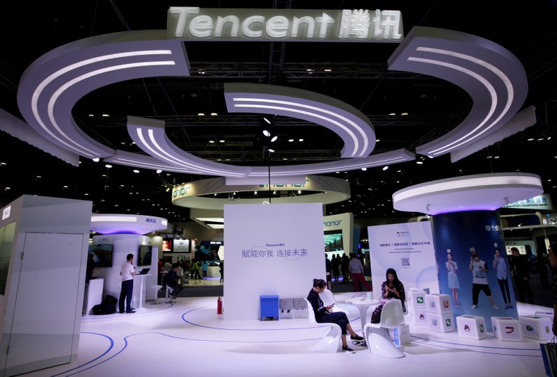FILE PHOTO: People use smartphones at a Tencent booth during the Global Mobile Internet