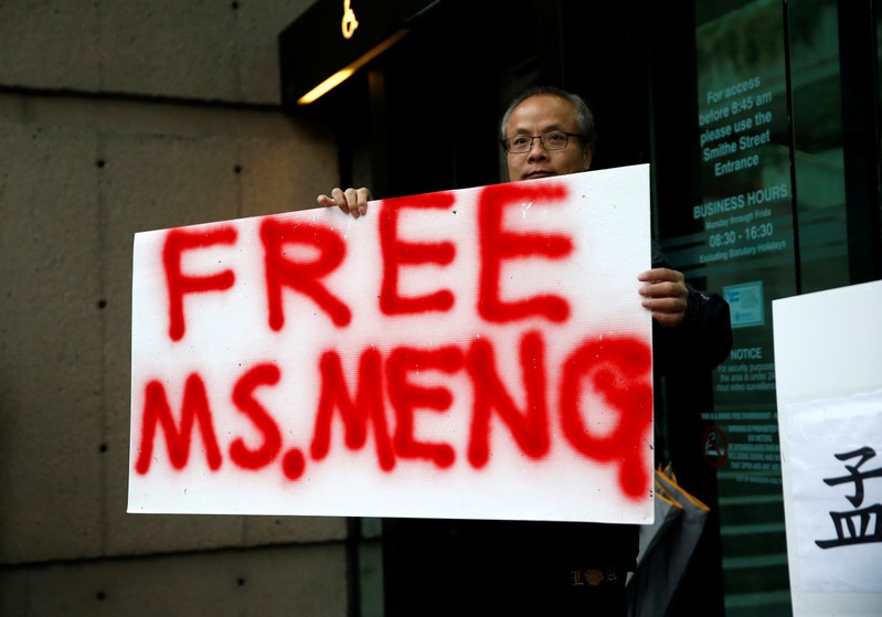 FILE PHOTO: Long holds a sign outside the B.C. Supreme Court bail hearing of Huawei CFO Meng
