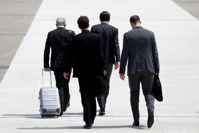 FILE PHOTO: Businessmen walk on the esplanade of La Defense financial and business district in