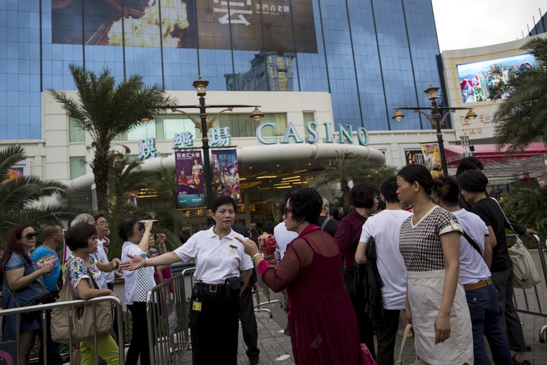 FILE PHOTO: People line up outside Broadway Macau casino, run by Galaxy Entertainment Group, in