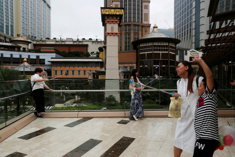 FILE PHOTO: Visitors take selfies at Venetian Macao, built by Las Vegas Sands, in Macau