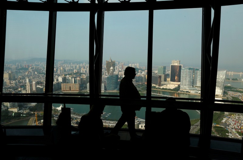 FILE PHOTO: A visitor walks inside Macau Tower overlooking the skyline of Macau peninsula