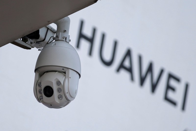 FILE PHOTO: A surveillance camera is seen next to a sign of Huawei in Beijing